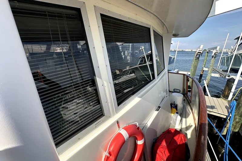 Slide: The Image of 1985 Chris-Craft 500 Constellation yacht docked, featuring windows and safety equipment. - 8