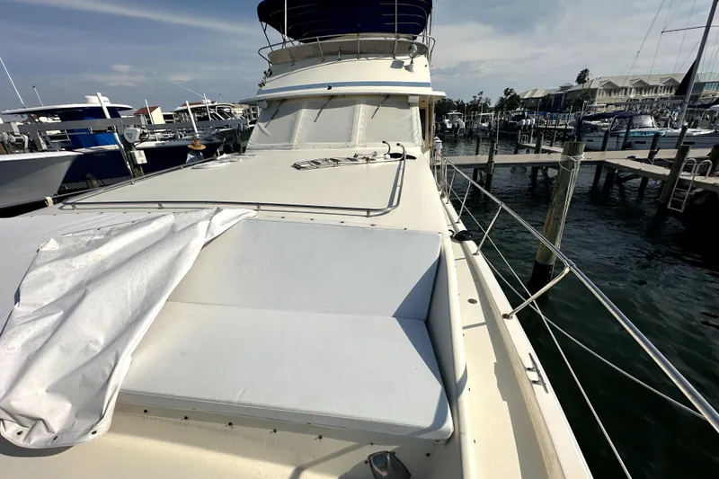 Slide: The Image of 1985 Chris-Craft 500 Constellation yacht docked at marina, showcasing spacious deck. - 88
