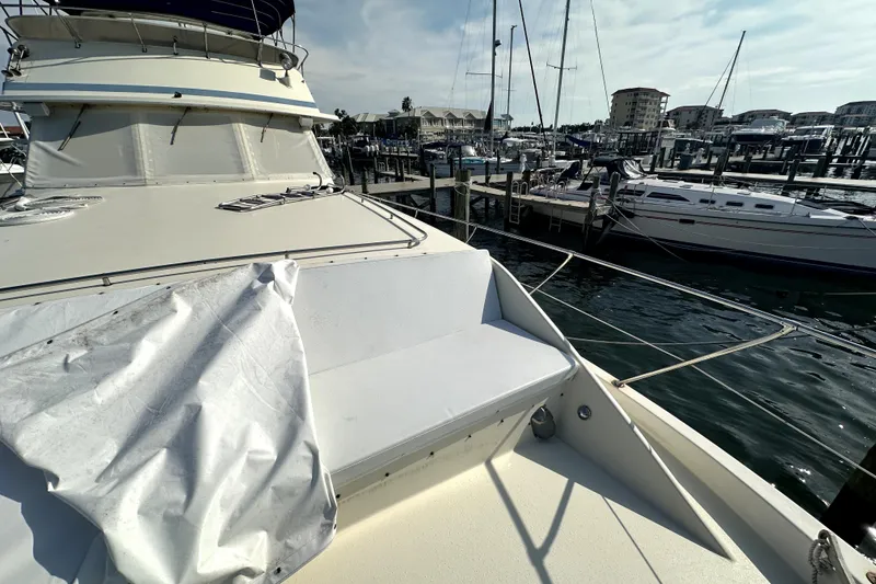 Slide: The Image of 1985 Chris-Craft 500 Constellation yacht docked at marina, featuring spacious deck and seating. - 89