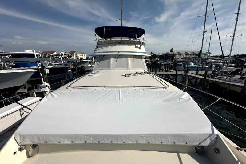 Slide: The Image of 1985 Chris-Craft 500 Constellation yacht docked at marina under blue sky. - 90