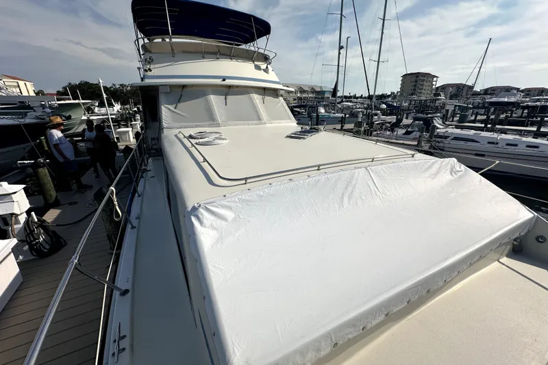 Slide: The Image of 1985 Chris-Craft 500 Constellation yacht docked at marina, covered deck, clear sky. - 94