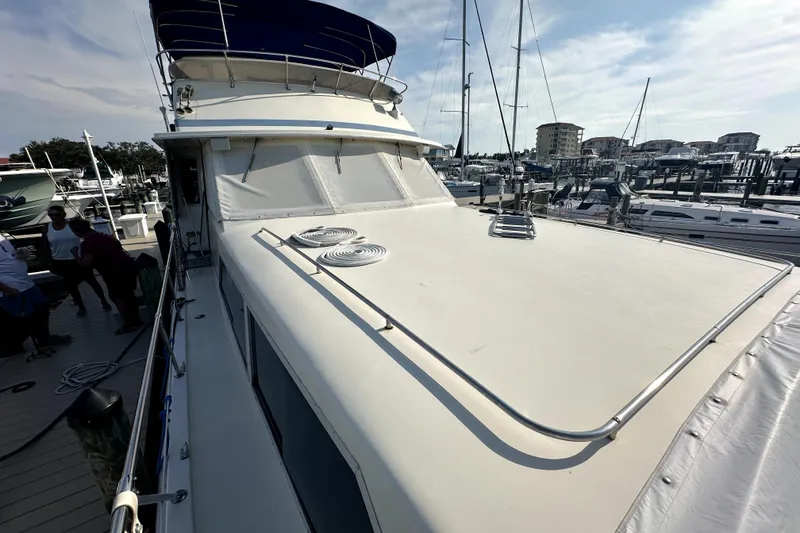 Slide: The Image of 1985 Chris-Craft 500 Constellation yacht docked at marina, showcasing spacious deck and sleek design. - 95