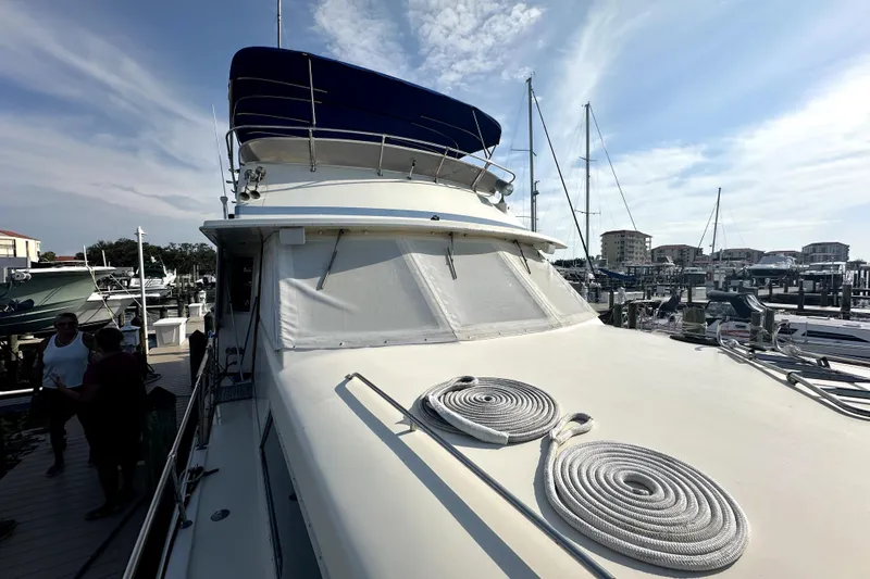 Slide: The Image of 1985 Chris-Craft 500 Constellation yacht docked at marina, featuring coiled ropes on deck. - 97
