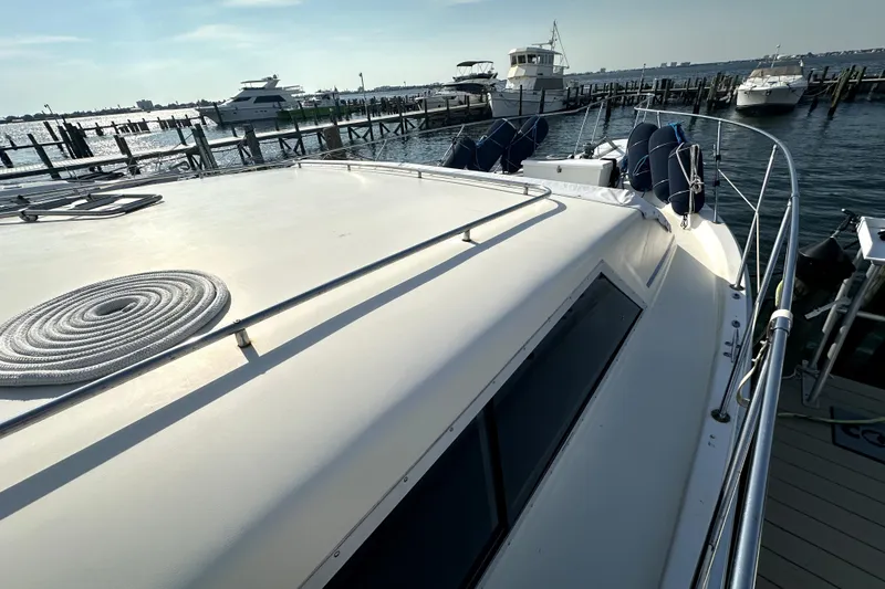 Slide: The Image of 1985 Chris-Craft 500 Constellation yacht docked at marina, sunny day, calm waters. - 98