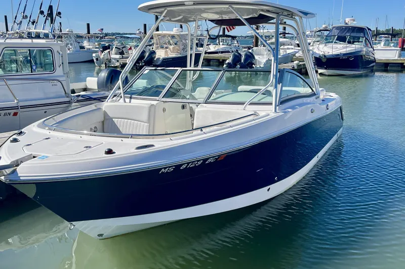 Slide: The Image of 2014 Robalo R247 Dual Console boat docked in marina, clear blue water. - 1