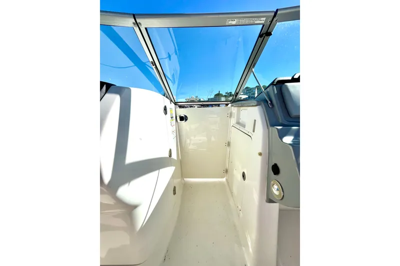 Slide: The Image of 2014 Robalo R247 Dual Console boat interior with clear windshield and bright sunlight. - 10
