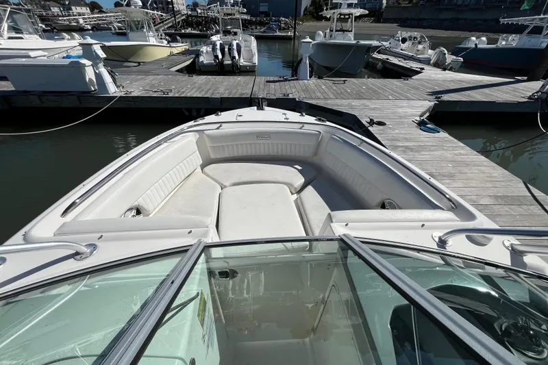Slide: The Image of 2014 Robalo R247 Dual Console boat docked at marina, featuring spacious seating area. - 11