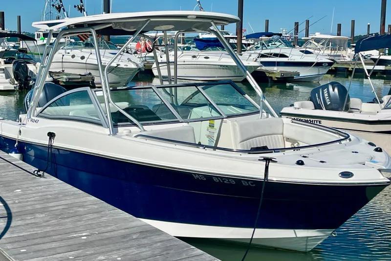 Slide: The Image of 2014 Robalo R247 Dual Console boat docked in a marina. - 2