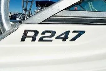 Slide: The Image of 2014 Robalo R247 Dual Console boat emblem with sleek design. - 3