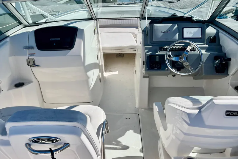 Slide: The Image of 2014 Robalo R247 Dual Console boat interior with steering wheel and seating. - 5