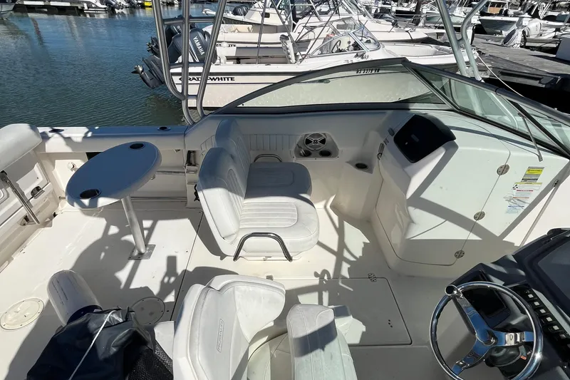 Slide: The Image of 2014 Robalo R247 Dual Console boat interior with seating and steering wheel at marina. - 8