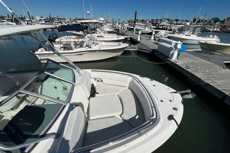 Slide: The Image of 2014 Robalo R247 Dual Console boat docked at a marina with other vessels. - 9