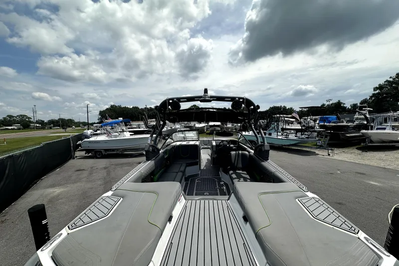Slide: The Image of 2016 Nautique Super Air Nautique G25 Coastal Edition boat, rear view, wet deck, cloudy sky. - 16