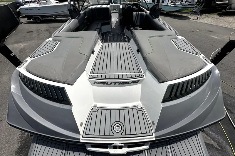 Slide: The Image of 2016 Nautique Super Air Nautique G25 Coastal Edition boat at a marina under cloudy skies. - 18