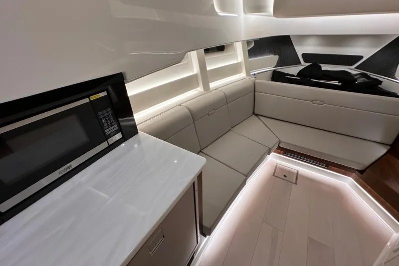 Slide: The Image of Interior of 2023 Sea Ray Sundancer 370 Outboard, featuring modern seating and a microwave. - 38