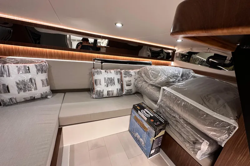 Slide: The Image of 2023 Sea Ray Sundancer 370 Outboard cabin interior with cushions and bedding. - 46