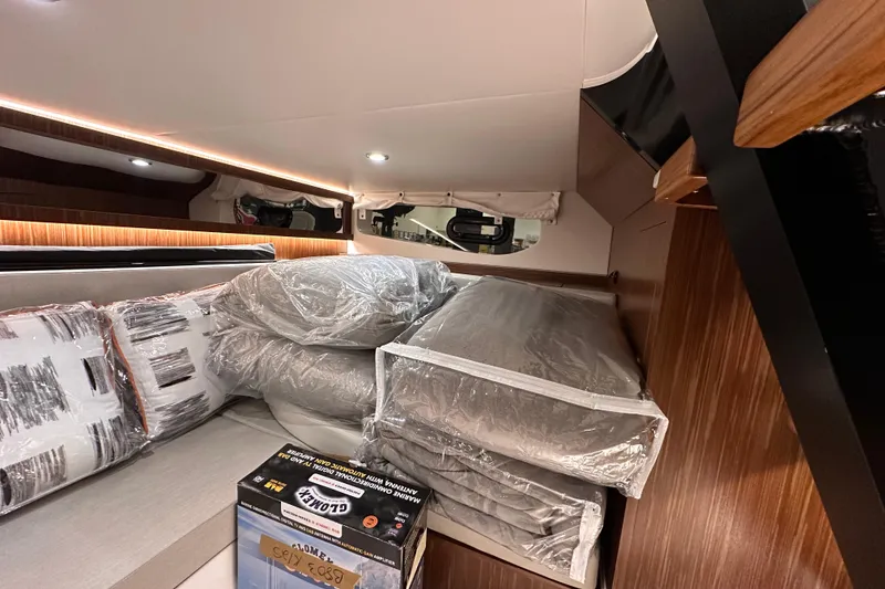Slide: The Image of 2023 Sea Ray Sundancer 370 Outboard cabin interior with bedding and cushions. - 47