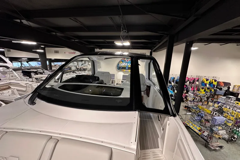 Slide: The Image of 2023 Sea Ray Sundancer 370 Outboard displayed in a showroom with boating accessories. - 48