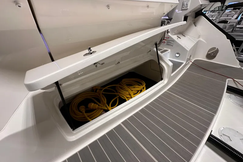 Slide: The Image of 2023 Sea Ray Sundancer 370 Outboard storage compartment with coiled yellow cables. - 8