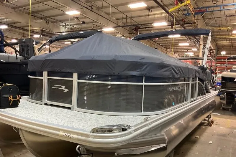 Slide: The Image of 2026 Bennington 22SXSR pontoon boat with cover in a warehouse setting. - 1