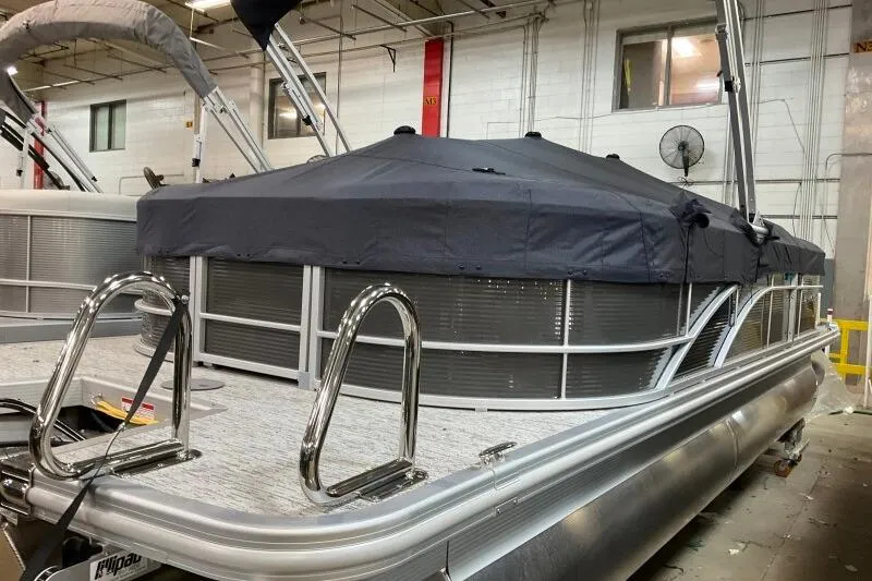 Slide: The Image of 2026 Bennington 22SXSR pontoon boat with cover in a showroom setting. - 3