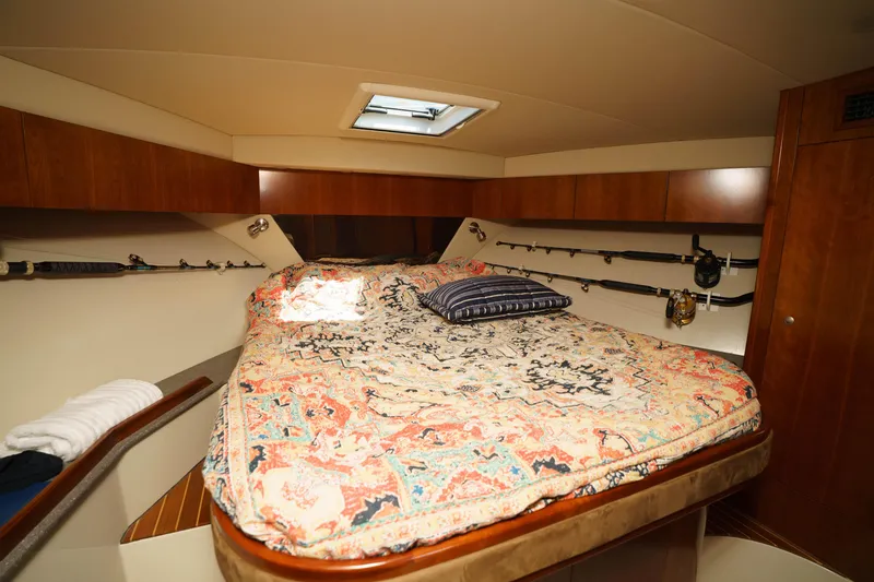Slide: The Image of Luxurious cabin interior of 2011 Rampage 41 Express yacht with cozy bed and fishing rods. - 14