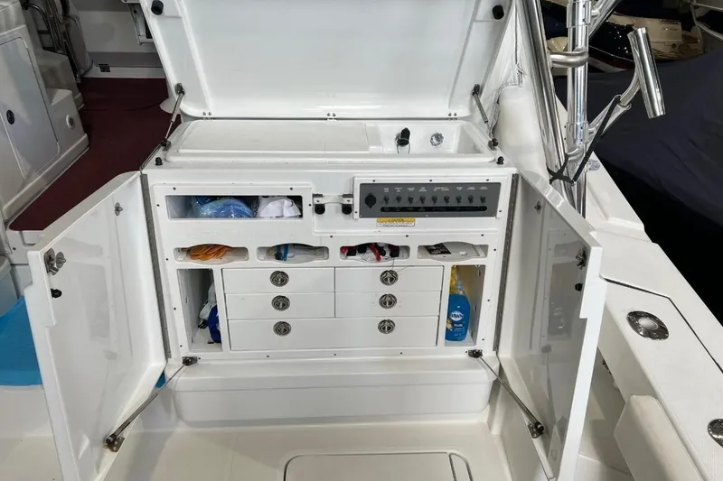 Slide: The Image of 2011 Rampage 41 Express boat storage compartment with open doors and organized shelves. - 8