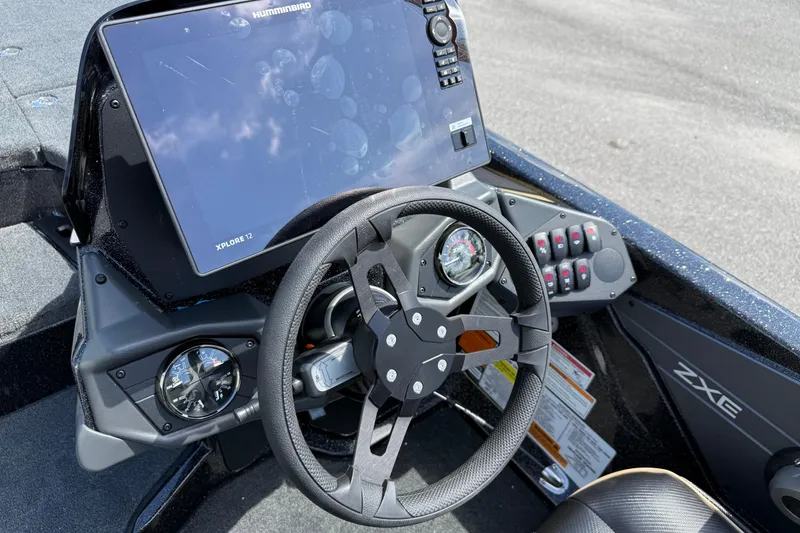 Slide: The Image of 2026 Skeeter ZXE21 boat dashboard with steering wheel and advanced navigation system. - 16