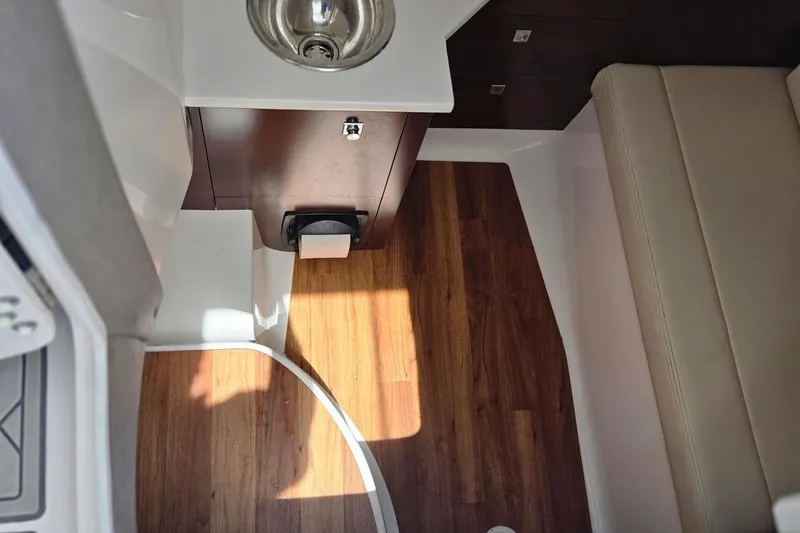 Slide: The Image of Interior of 2022 Chaparral 280 OSX boat with wood flooring and compact sink. - 11