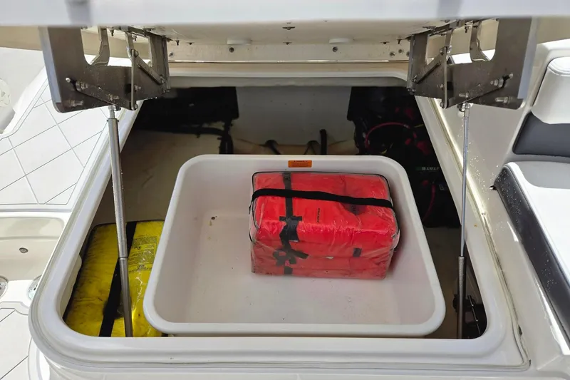 Slide: The Image of Storage compartment of 2022 Chaparral 280 OSX boat with safety equipment. - 13