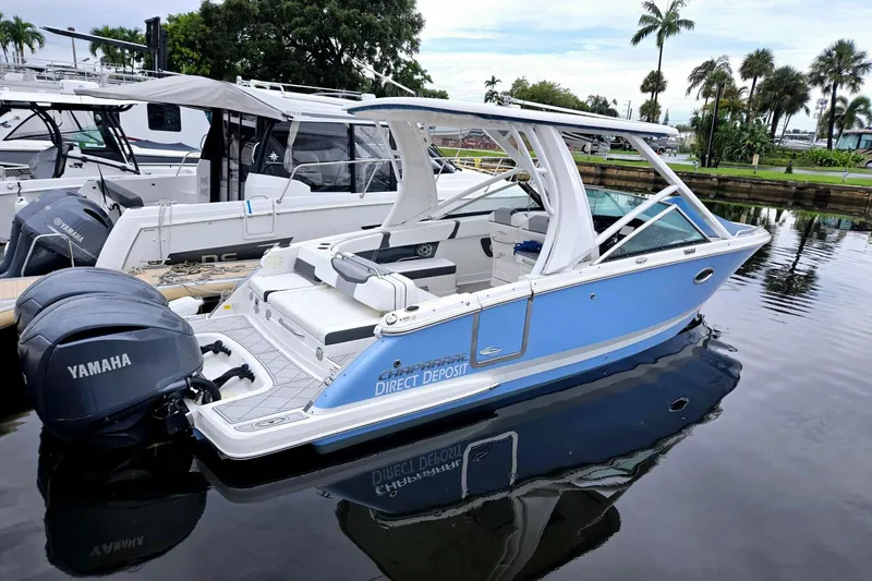Slide: The Image of 2022 Chaparral 280 OSX boat docked, featuring Yamaha engines, sleek design, and blue exterior. - 26