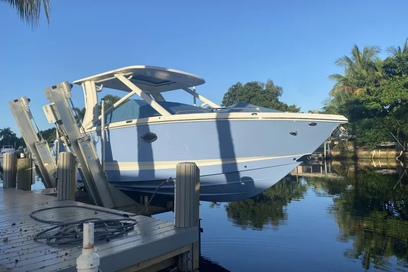 Slide: The Image of 2022 Chaparral 280 OSX boat docked on a sunny day by the water. - 4