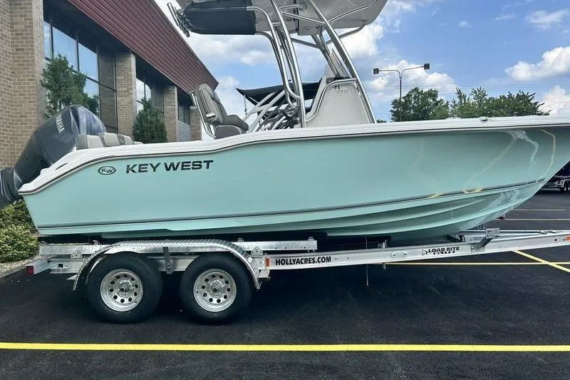 The Image of 2025 Key West 219 FS boat on trailer, parked outdoors, clear sky background. - 1