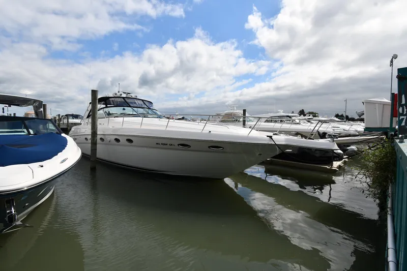 The Image of 2000 Sea Ray 460 Sundancer yacht docked at marina under cloudy sky. - 0