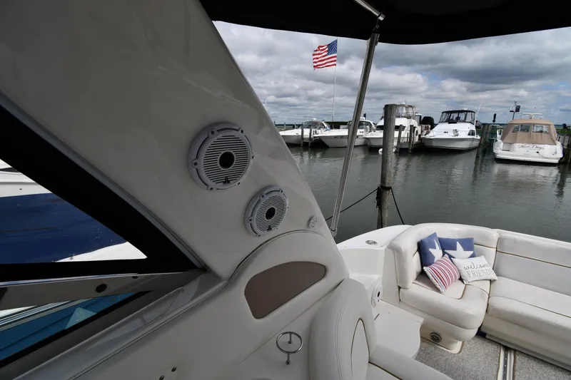 Slide: The Image of 2000 Sea Ray 460 Sundancer yacht interior with speakers, docked near other boats, American flag visible. - 15