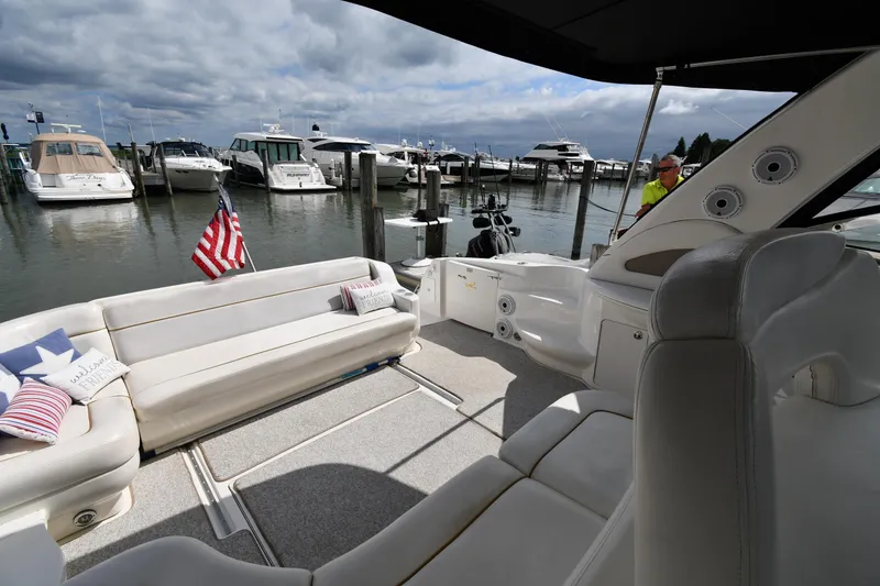 Slide: The Image of 2000 Sea Ray 460 Sundancer yacht interior with seating, docked at marina under cloudy sky. - 19