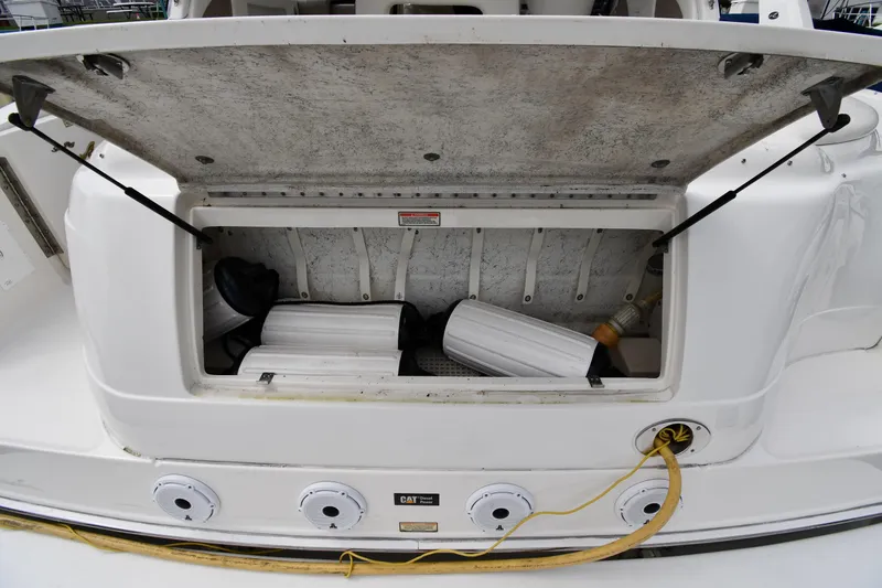 Slide: The Image of Open storage compartment on a 2000 Sea Ray 460 Sundancer boat, showing equipment inside. - 22