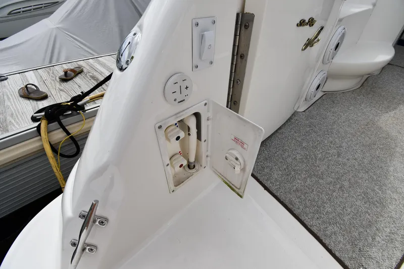 Slide: The Image of Sea Ray 460 Sundancer 2000 boat deck with open utility panel and docked accessories. - 24