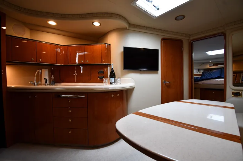 Slide: The Image of Luxurious interior of 2000 Sea Ray 460 Sundancer yacht with modern kitchen and dining area. - 38