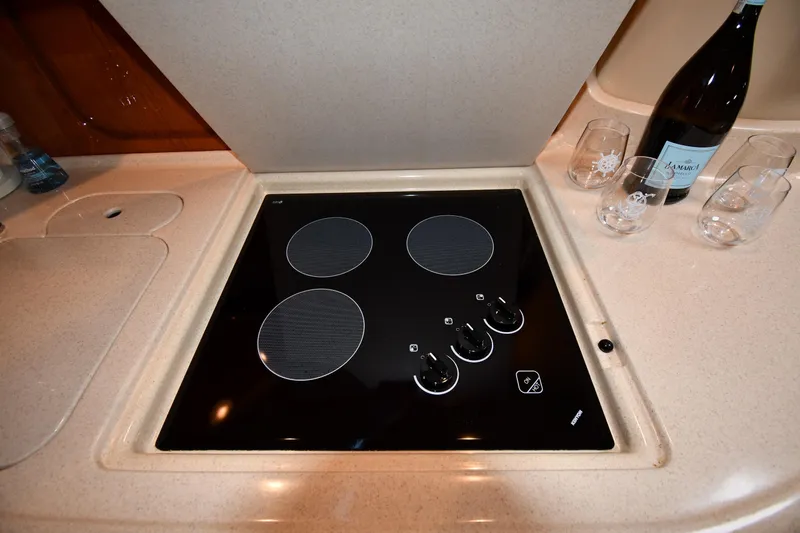 Slide: The Image of Stovetop in 2000 Sea Ray 460 Sundancer yacht kitchen with wine and glasses nearby. - 43