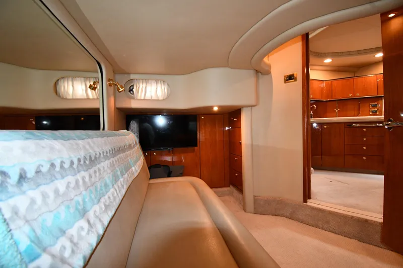 Slide: The Image of Interior of 2000 Sea Ray 460 Sundancer yacht, featuring luxurious seating and wooden cabinetry. - 49