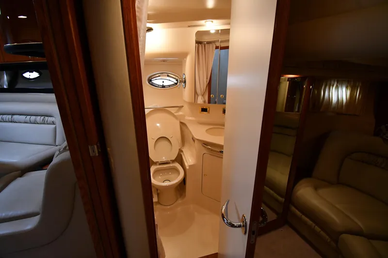 Slide: The Image of Interior of 2000 Sea Ray 460 Sundancer yacht, featuring a compact bathroom and seating area. - 51