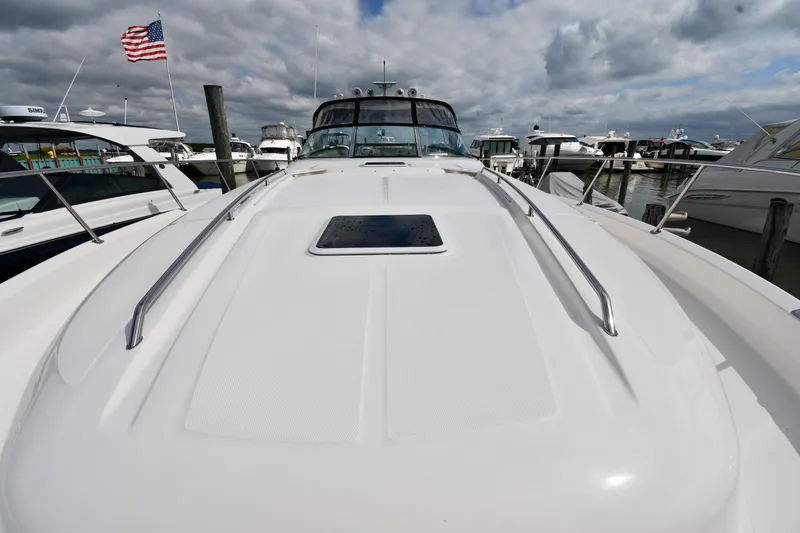 Slide: The Image of 2000 Sea Ray 460 Sundancer yacht docked, American flag waving, cloudy sky background. - 6