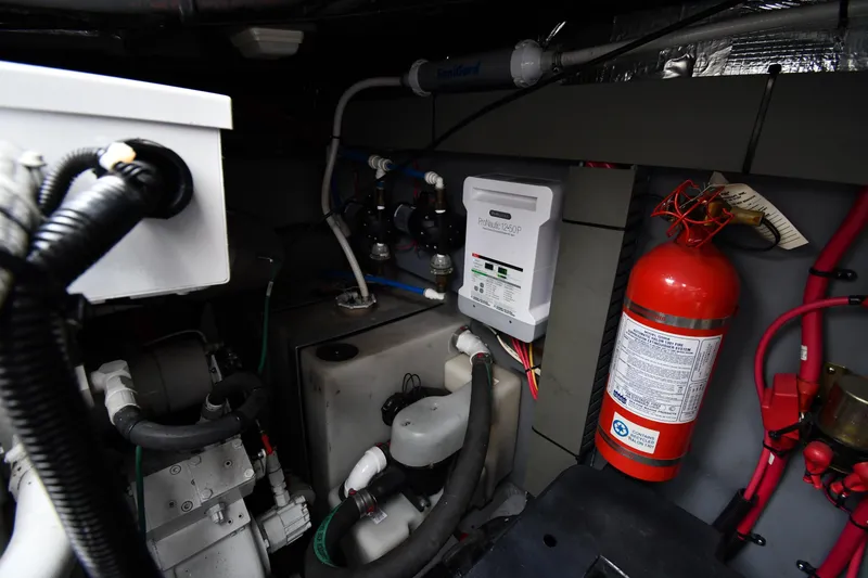 Slide: The Image of Engine room of 2000 Sea Ray 460 Sundancer with fire extinguisher and control panel. - 64