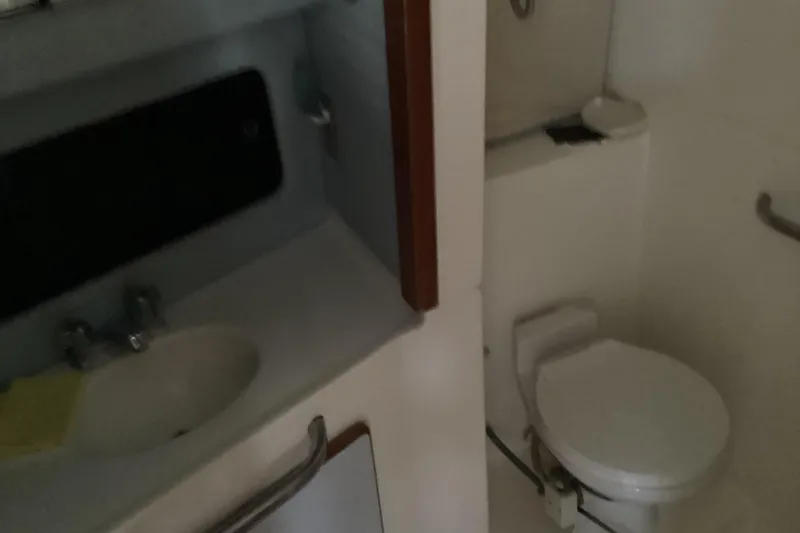 Slide: The Image of 1989 Sea Ray 380 Aft Cabin bathroom with sink and toilet. - 17