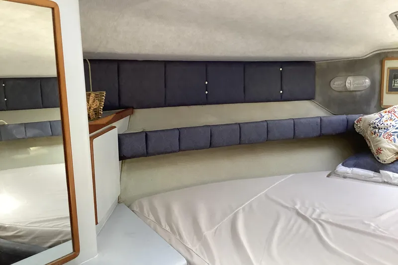 Slide: The Image of 1989 Sea Ray 380 Aft Cabin interior with cozy bed and decorative pillows. - 18