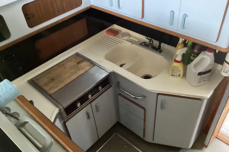 Slide: The Image of 1989 Sea Ray 380 Aft Cabin kitchen with sink, stove, and storage cabinets. - 19