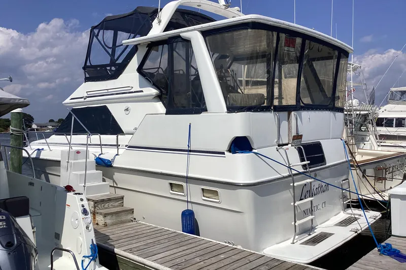 Slide: The Image of 1989 Sea Ray 380 Aft Cabin yacht docked at marina under blue sky. - 3