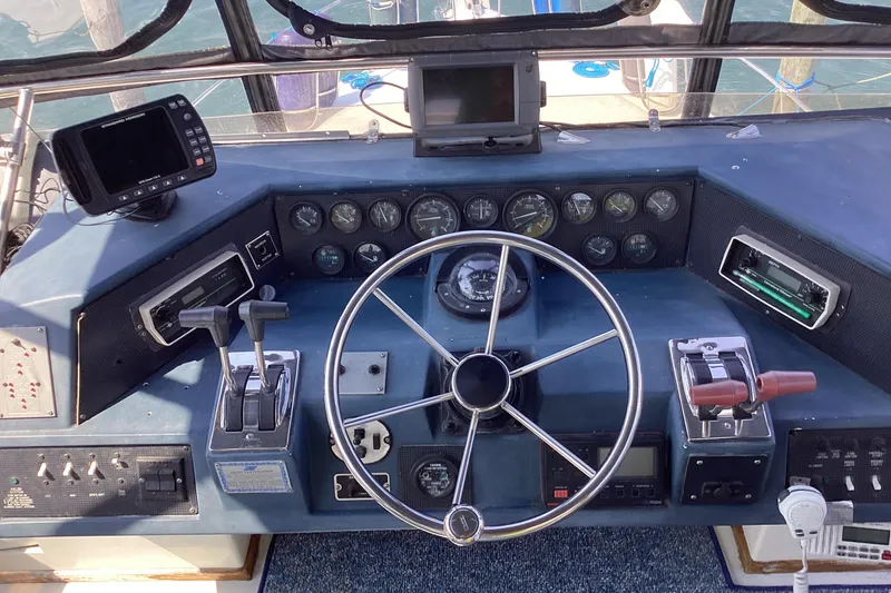 Slide: The Image of 1989 Sea Ray 380 Aft Cabin helm with steering wheel, gauges, and controls. - 6