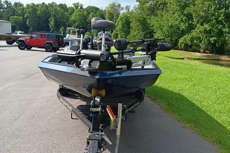 Slide: The Image of 2021 Ranger RT188P boat on trailer, parked near grassy area and red Jeep. - 5